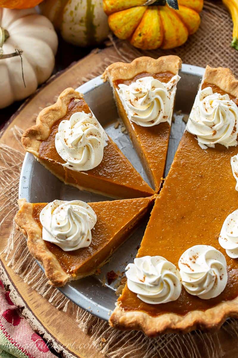 Overhead view of a sliced Libby's Pumpkin Pie topped with swirls of whipped cream