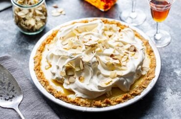 An amaretto cream pie topped with whipped cream and almonds