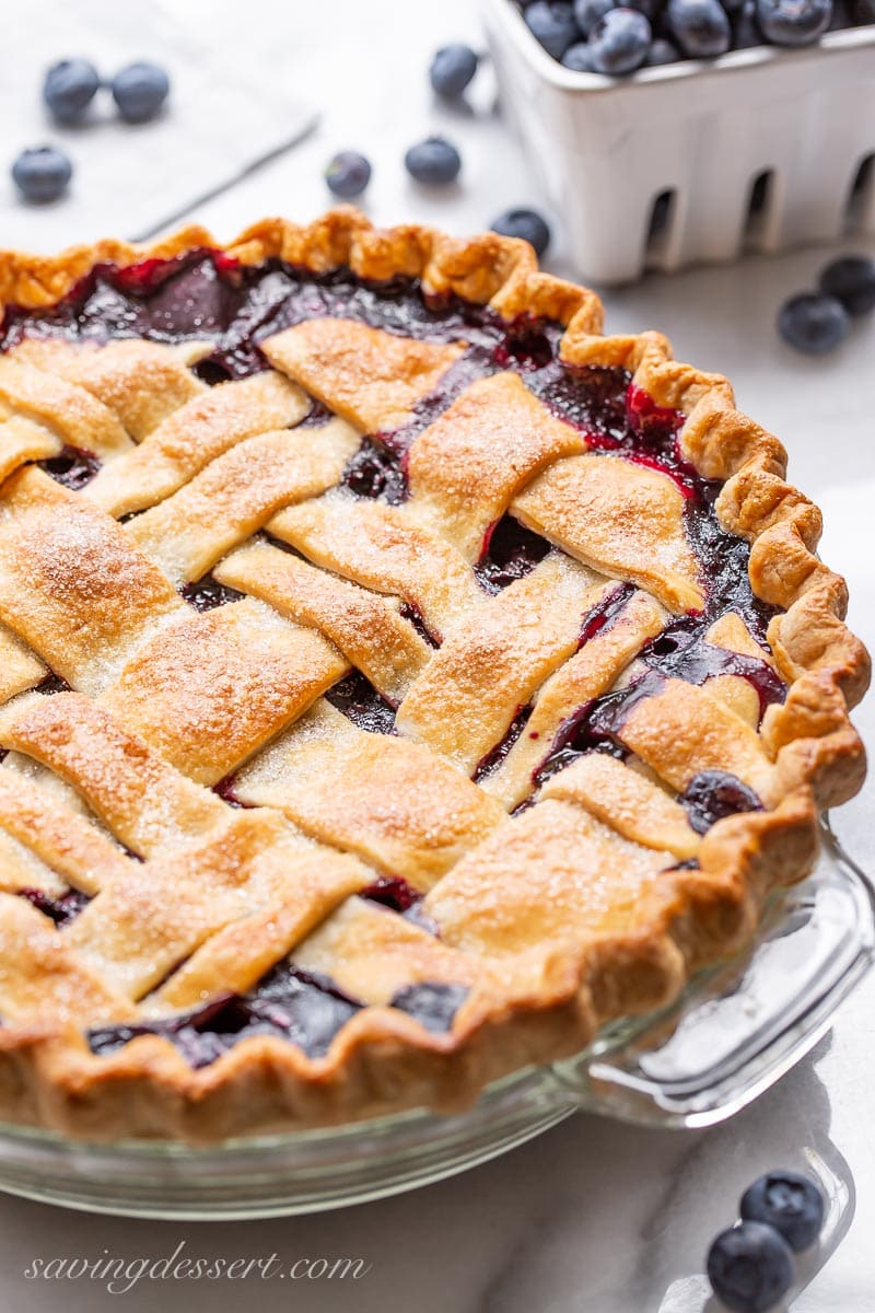 A side view of a lattice topped blueberry pie