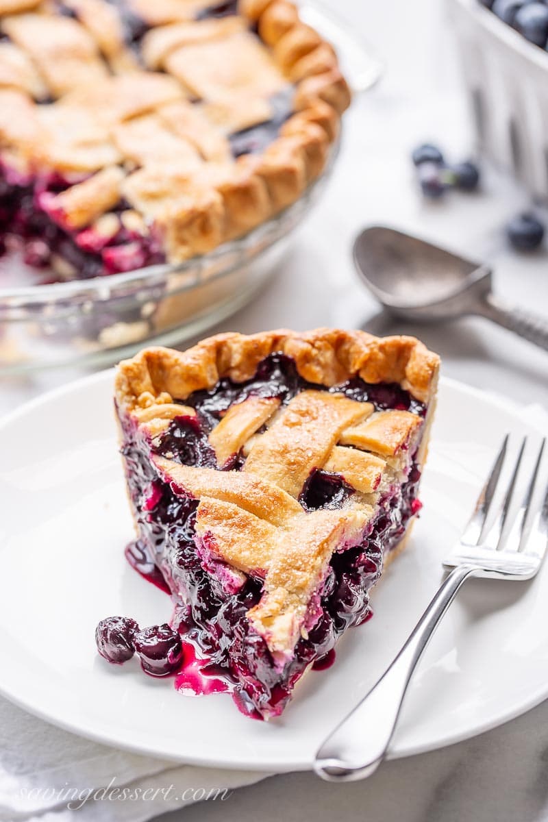 A slice of juicy blueberry pie on a plate