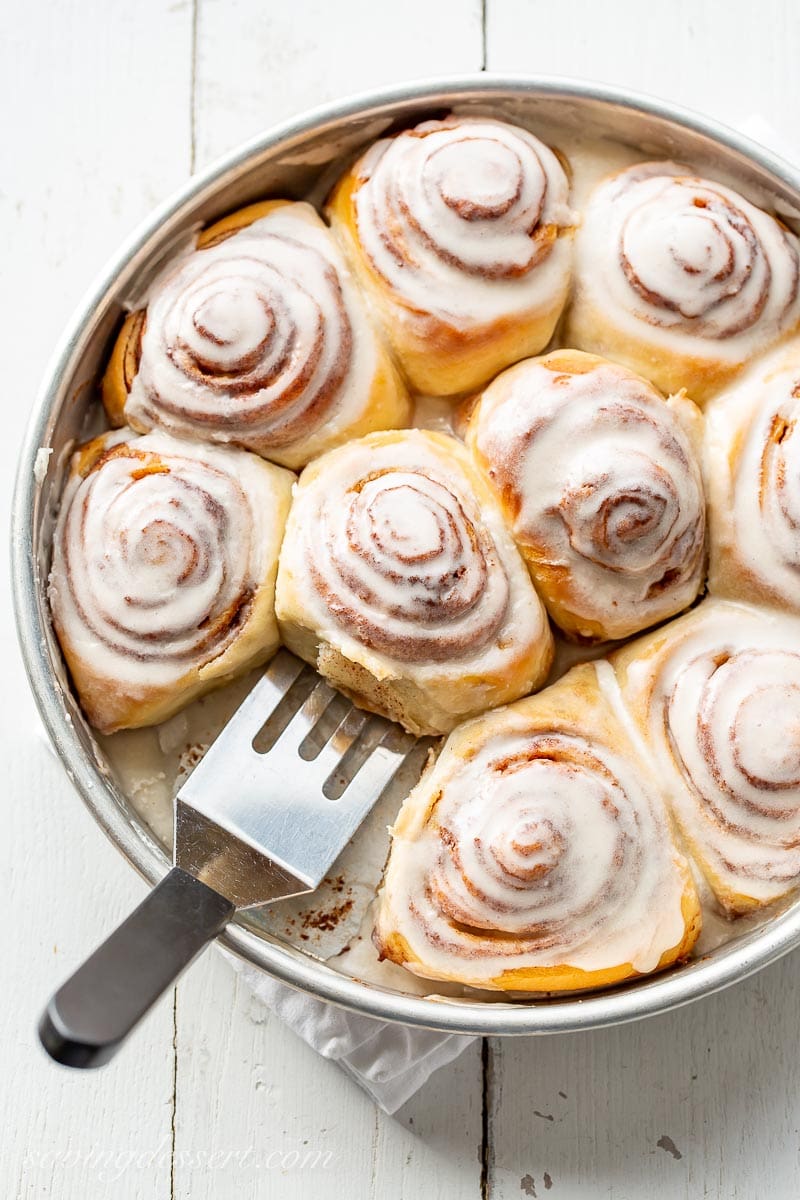 An overhead view of a pan filled with iced cinnamon rolls