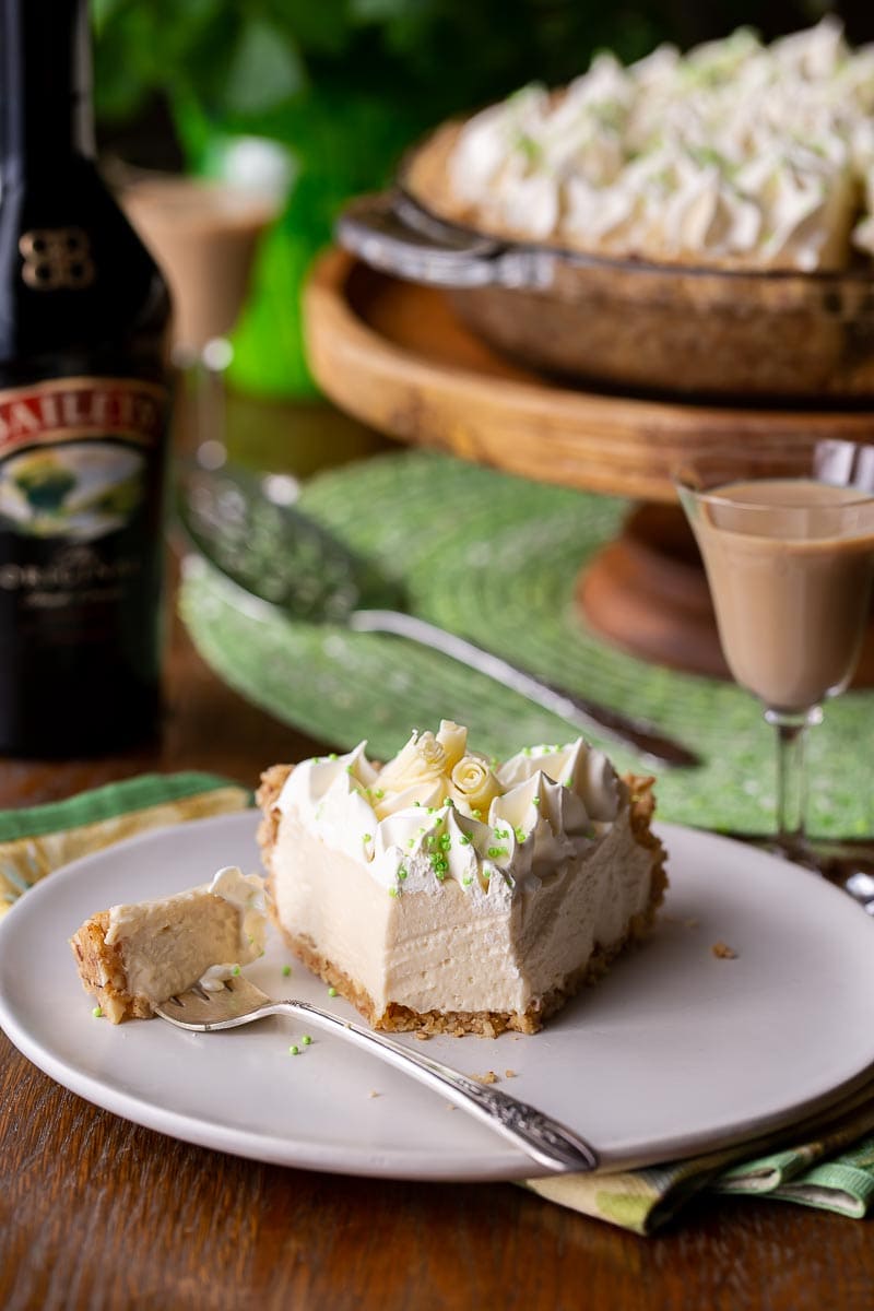 a slice of creamy pie on a plate served with Irish cream in a glass