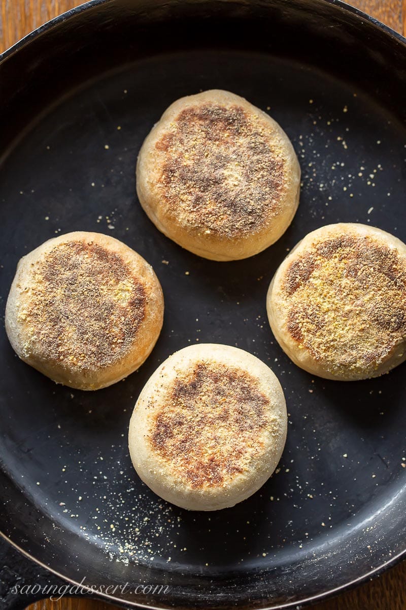 A cast iron skillet with English muffins