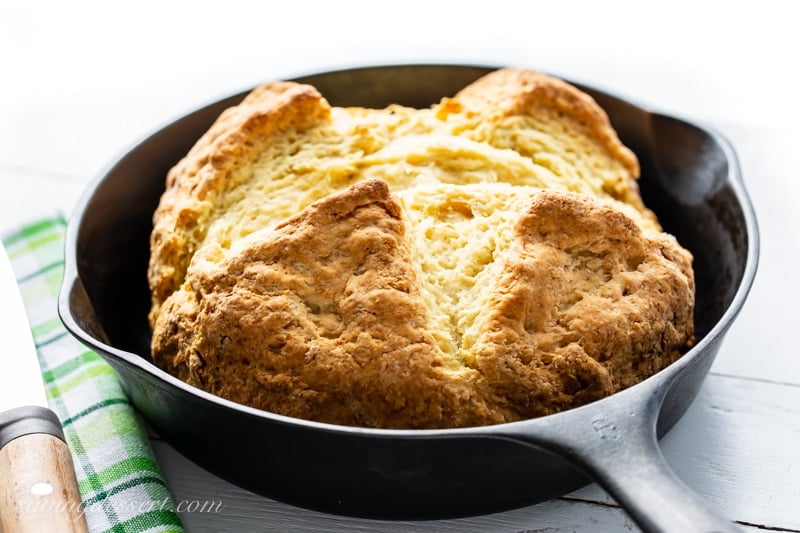 A cast iron skillet with a loaf of fresh baked Irish soda bread.