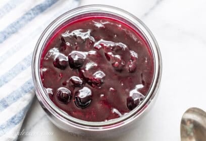 an overhead shot of a jar filled with homemade blueberry sauce