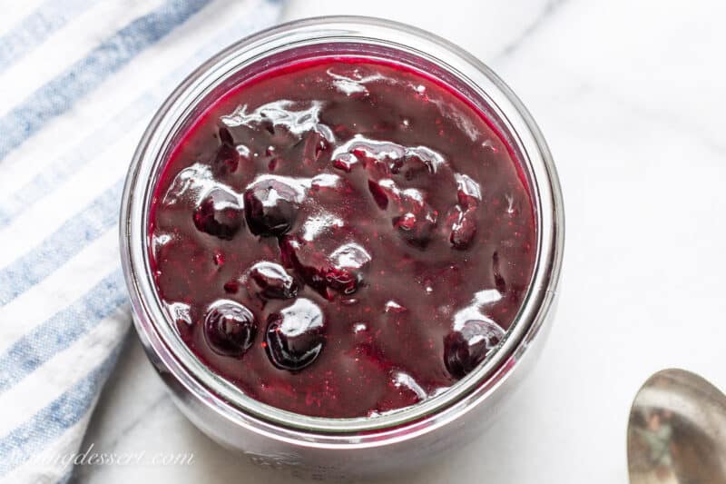 an overhead shot of a jar filled with homemade blueberry sauce