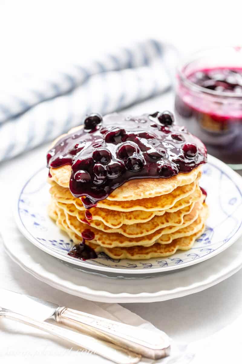 A stack of pancakes topped with blueberry sauce