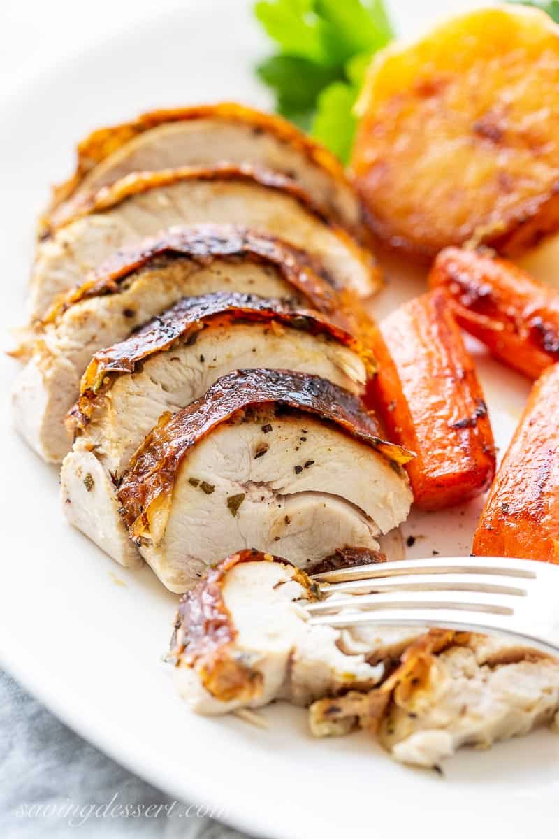 A dinner plate with roast chicken, carrots and potatoes