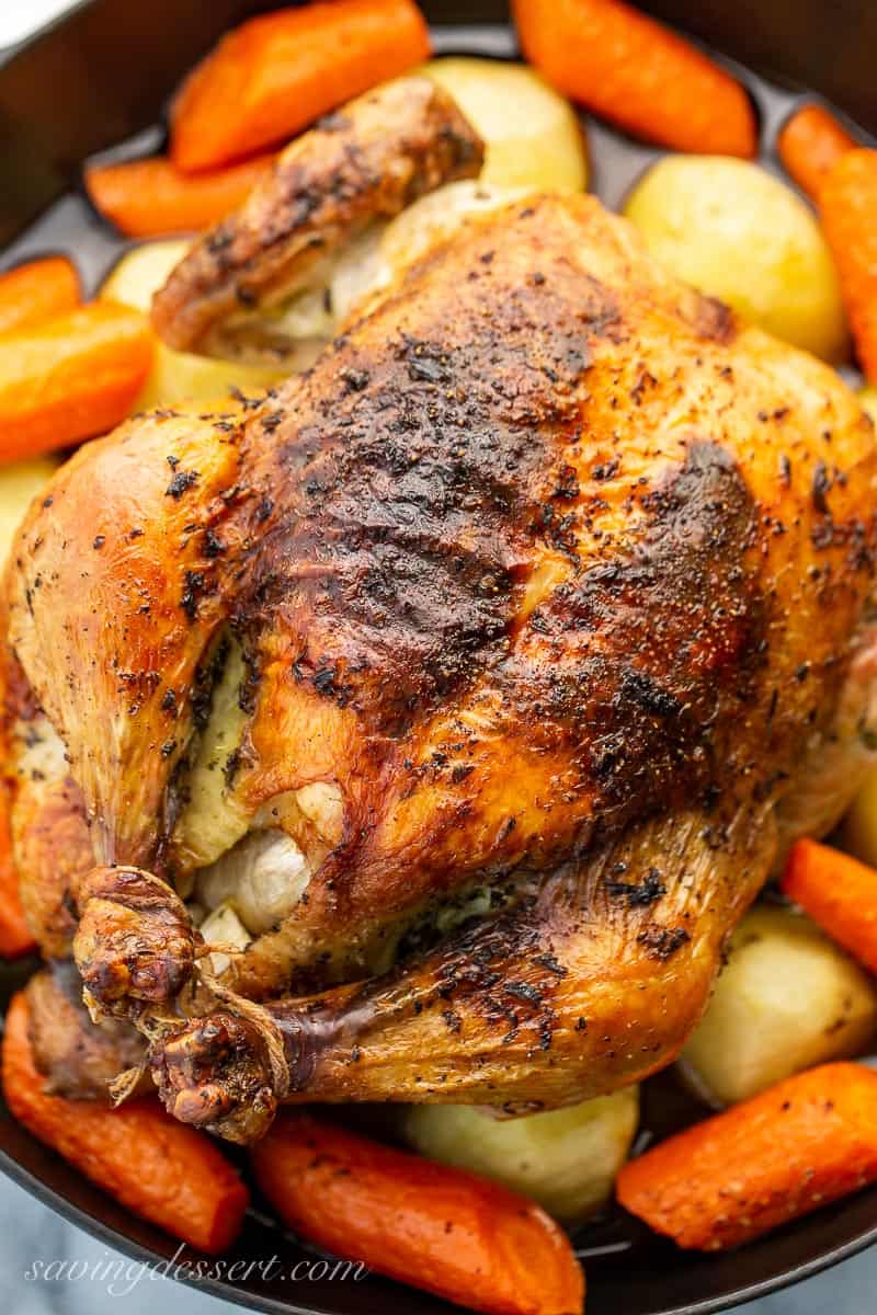 Closeup of a golden brown chicken with the drumsticks tied together