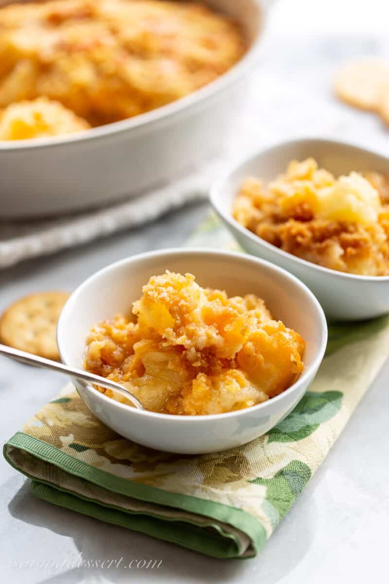 A single serving of hot pineapple casserole topped with crushed Ritz crackers