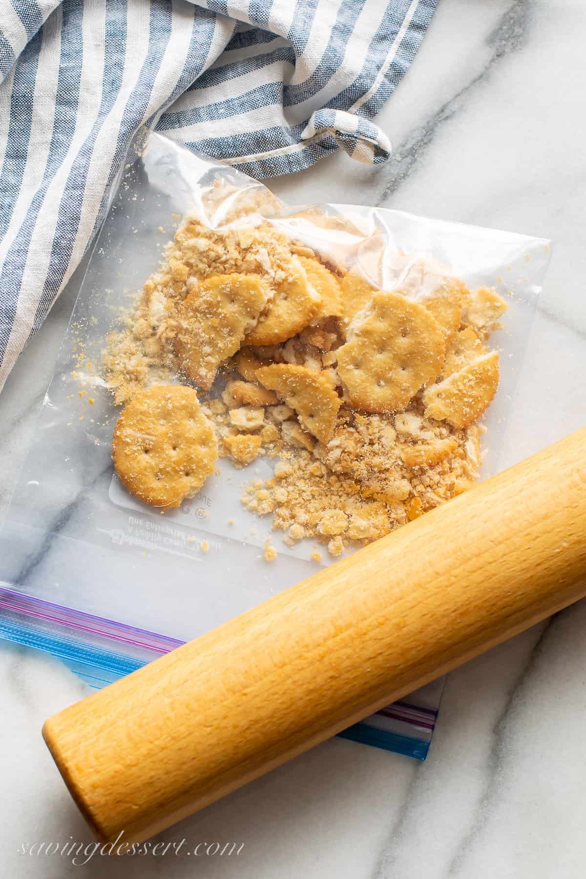 A bag of Ritz crackers being smashed with a rolling pin