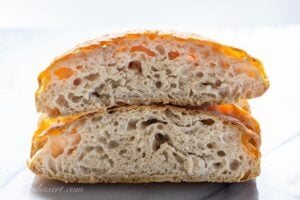 A loaf of artisan bread cut in half and stacked to show the inside of the bread