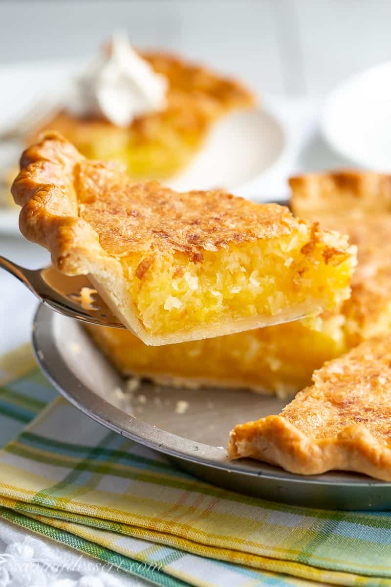 A side view of a slice of coconut pie being taken out of a pie plate