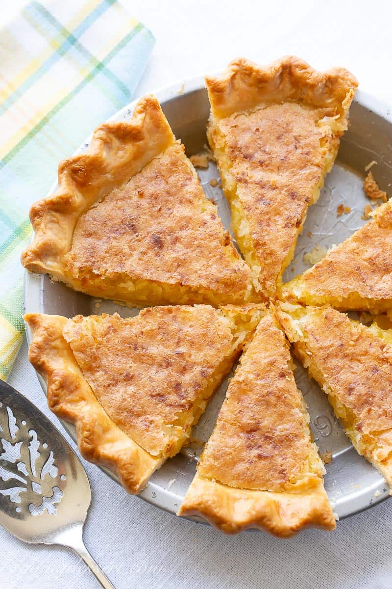 A sliced golden brown coconut pie