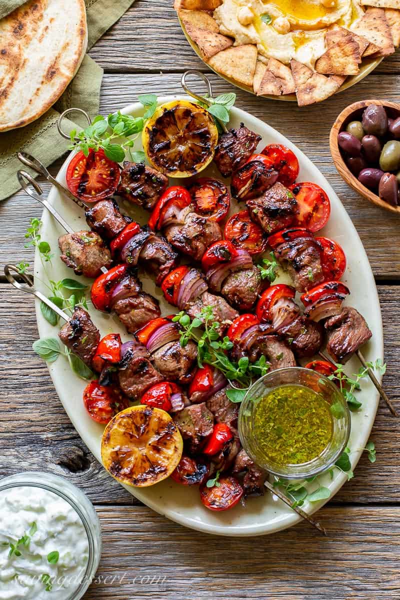 A platter of grilled lamb souvlaki, tzatziki, olives, hummus and pita breads