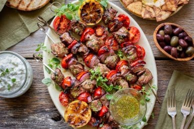 Grilled Lamb Souvlaki skewers with tzatziki, olives, pita bread and hummus