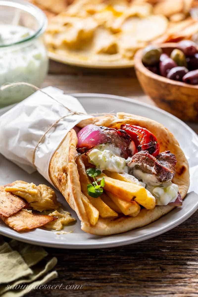 Grilled lamb wrapped in a pita bread with french fries, vegetables and sauce
