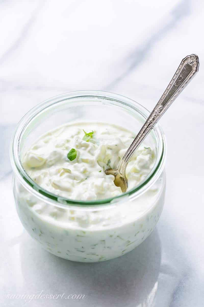 A jar of tzatziki sauce with a spoon