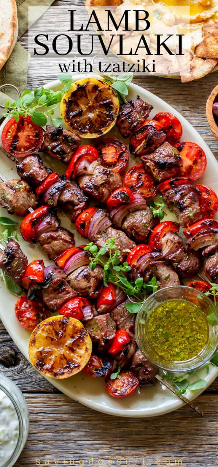 A platter of grilled skewers with red pepper, onion and lemons