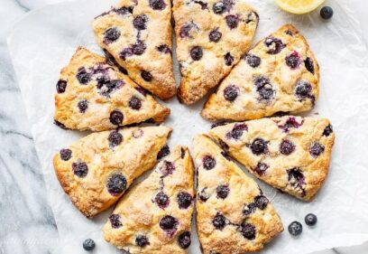 Scones cut into wedges with blueberries and lemon