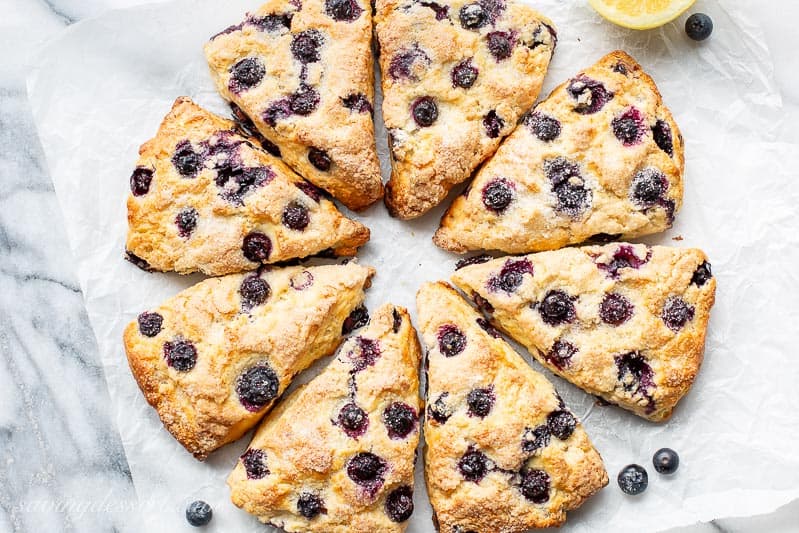 Scones cut into wedges with blueberries and lemon