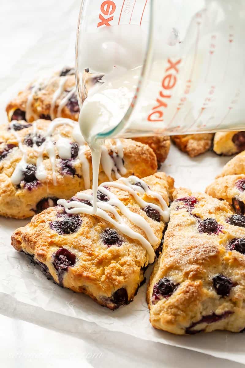 Lemon Blueberry Scones being drizzled with a lemon glaze