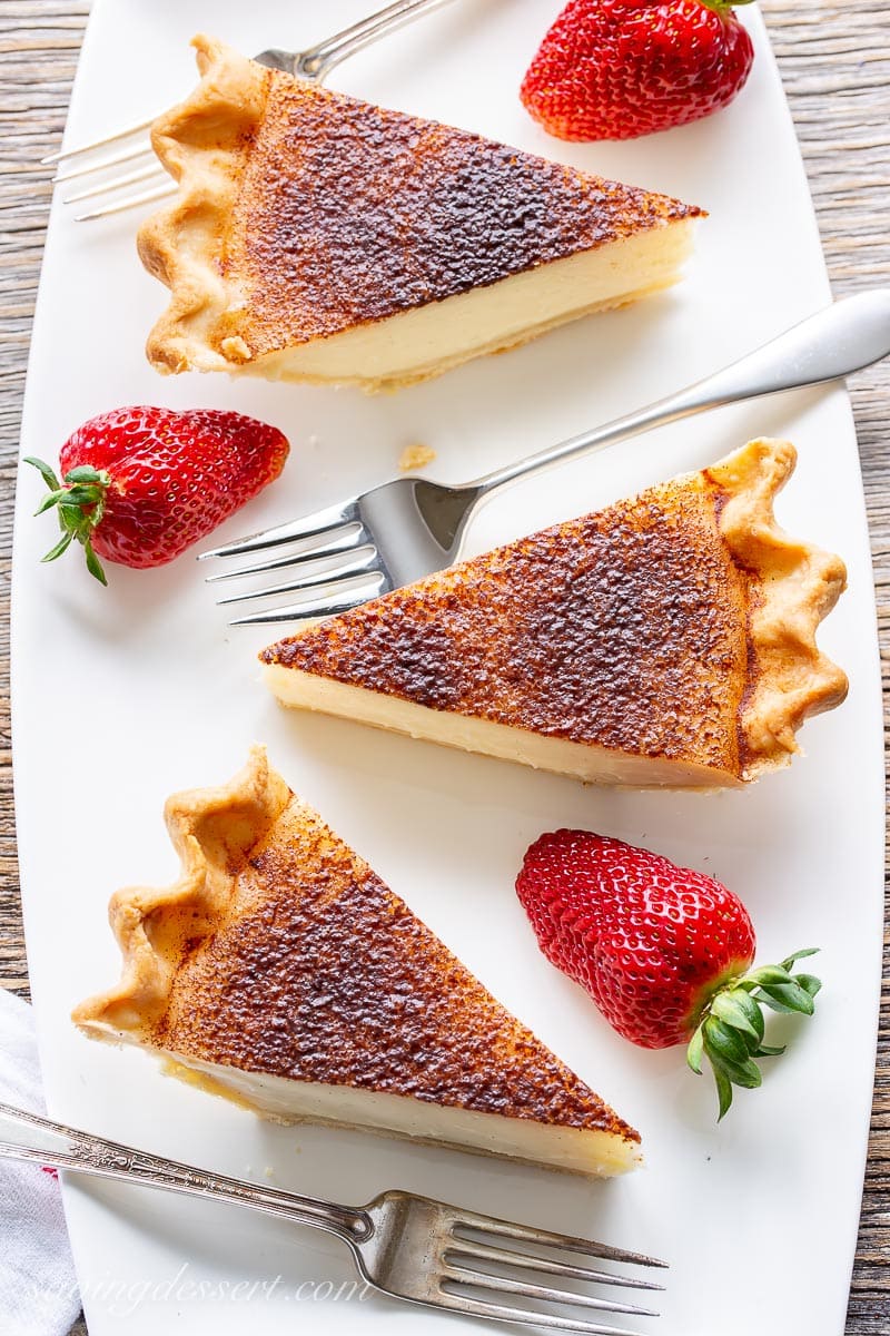 Slices of sugar cream pie on a platter served with strawberries