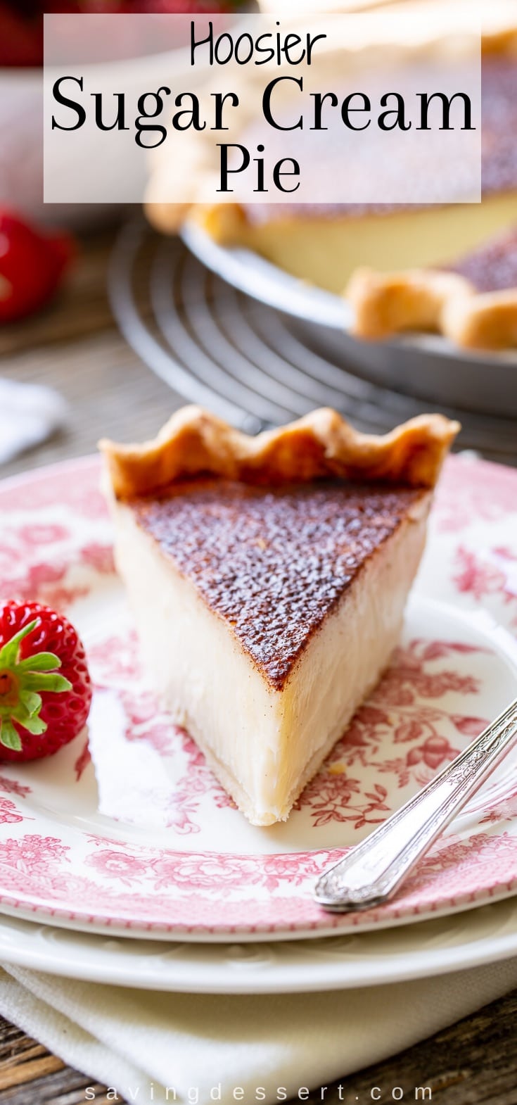 A slice of Hoosier Sugar Cream Pie on a plate served with strawberries