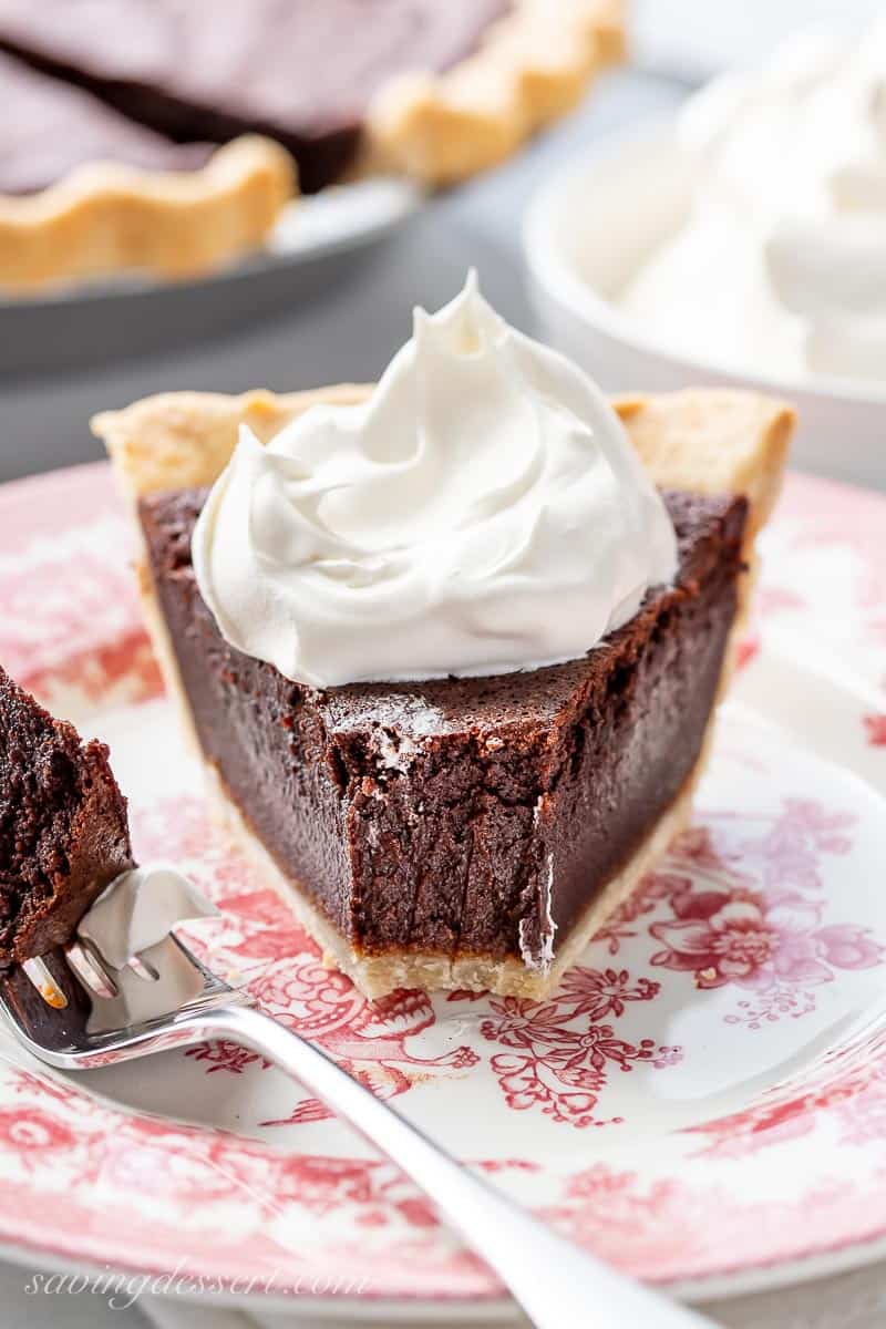 A straight on view of a piece of chocolate pie topped with whipped cream