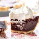Closeup of a partially eaten slice of Chocolate Chess Pie topped with billowy whipped cream