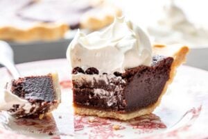 Closeup of a partially eaten slice of Chocolate Chess Pie topped with billowy whipped cream