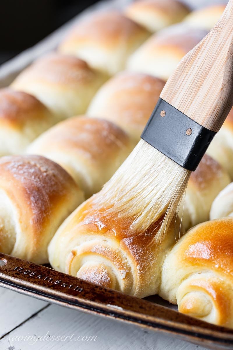 A pan of homemade Lion House Rolls brushed with melted butter