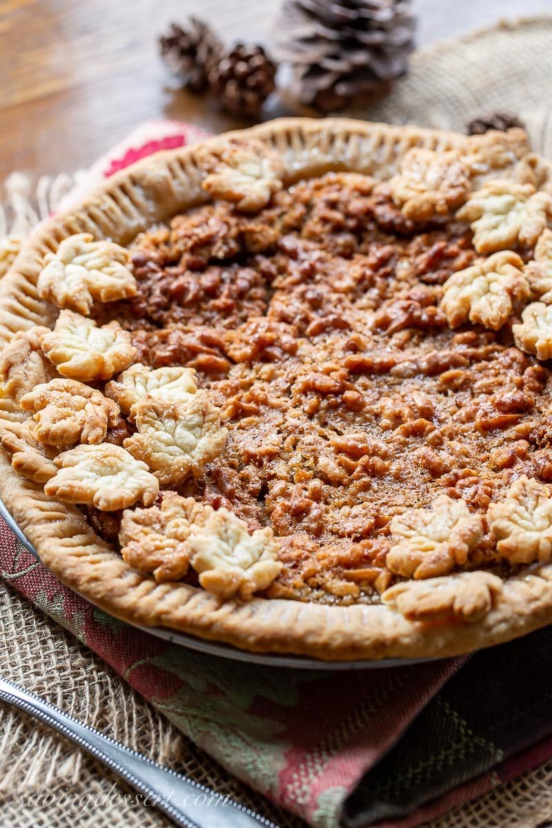 A side view of a maple walnut pie topped with crust cookies 