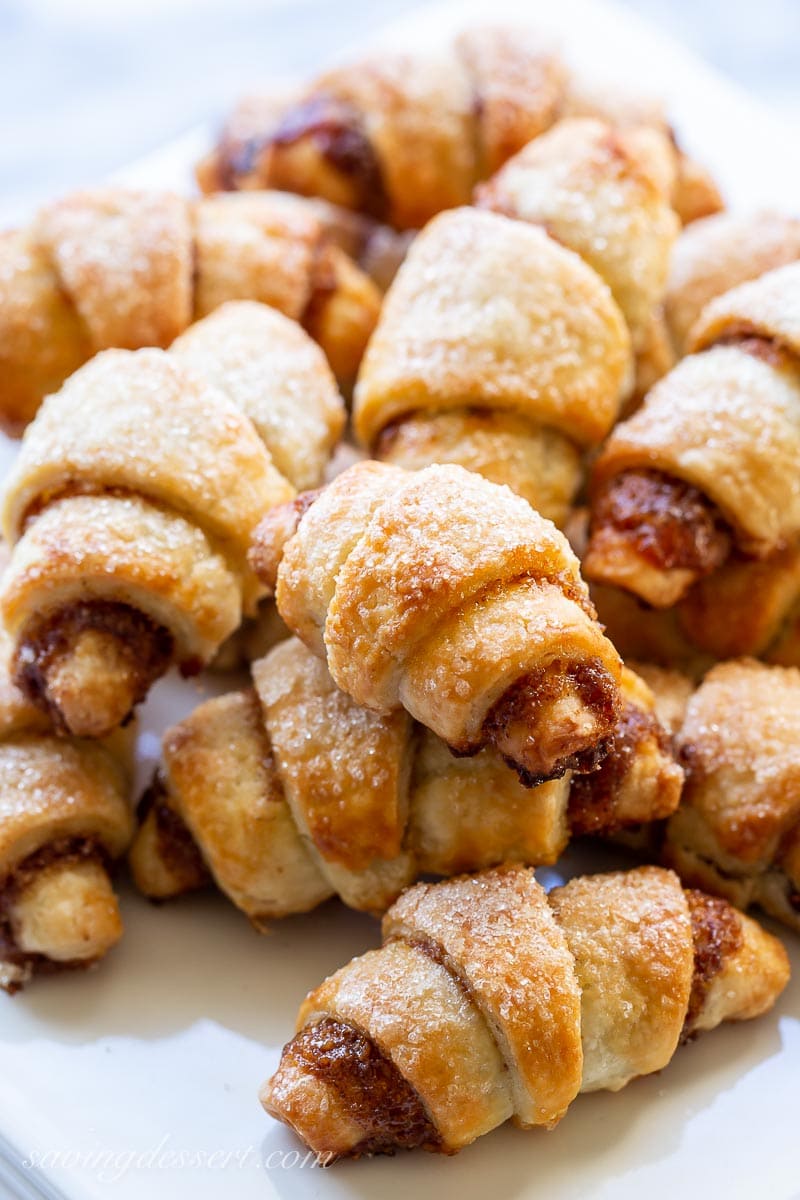 A plate of crescent shaped Rugelach cookies with a crispy sugary top