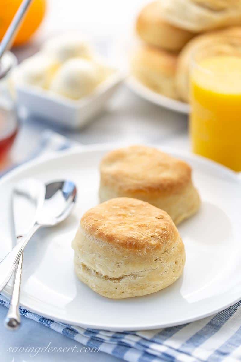 A plate of biscuits with orange juice and butter