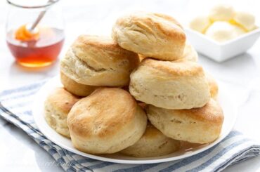 A plate of angel biscuits with butter and honey
