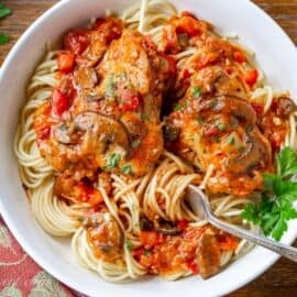 A bowl of spaghetti topped with a tomato sauce