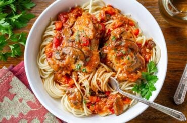 A bowl of spaghetti topped with a tomato sauce