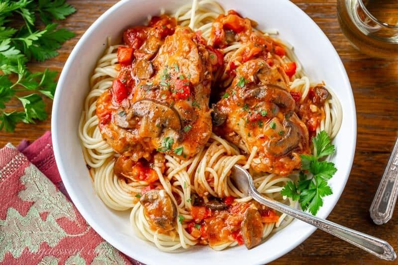 A bowl of spaghetti topped with a tomato sauce