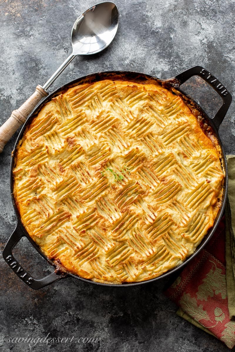 A skillet filled with cottage pie with mashed potatoes on top