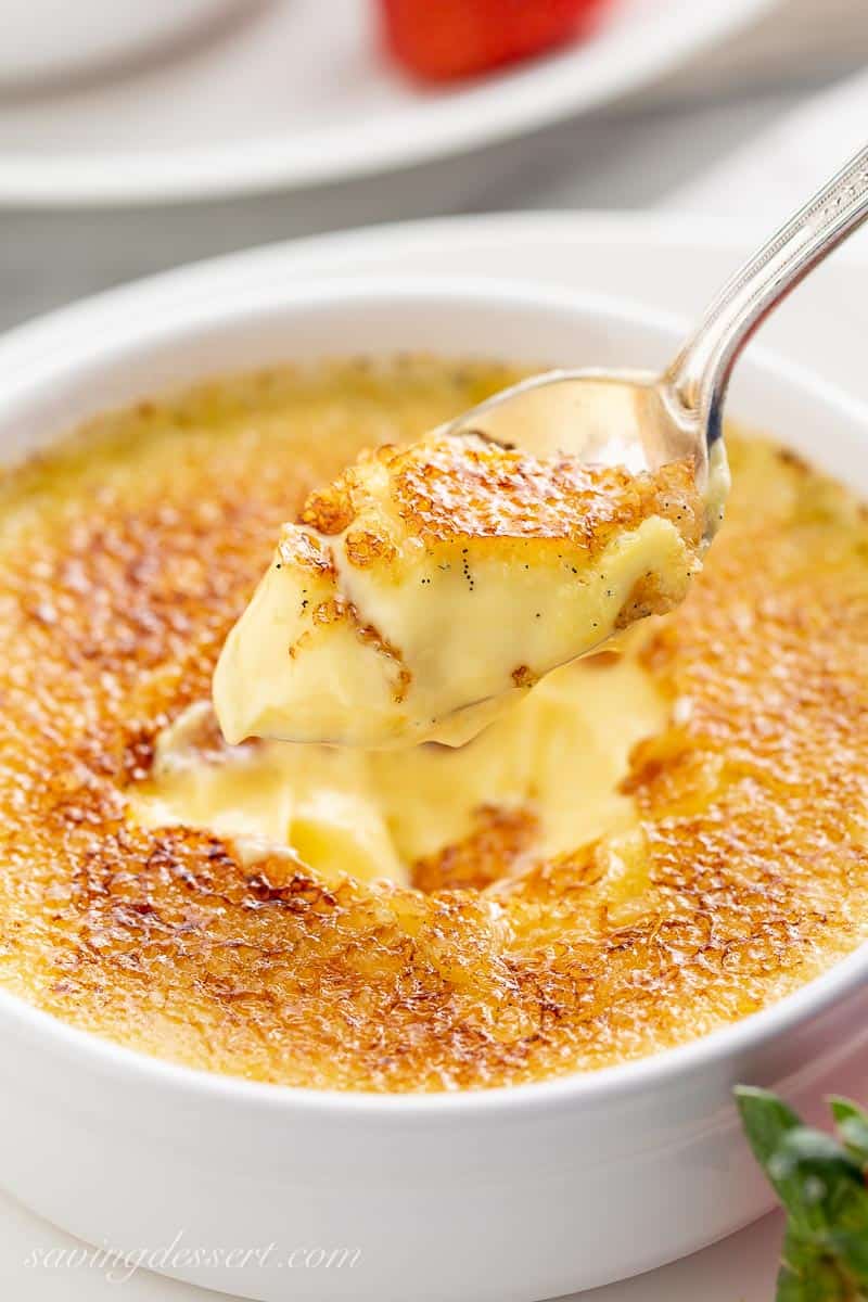 Closeup of a spoonful of creamy Crème Brûlée with a golden sugar candy crust
