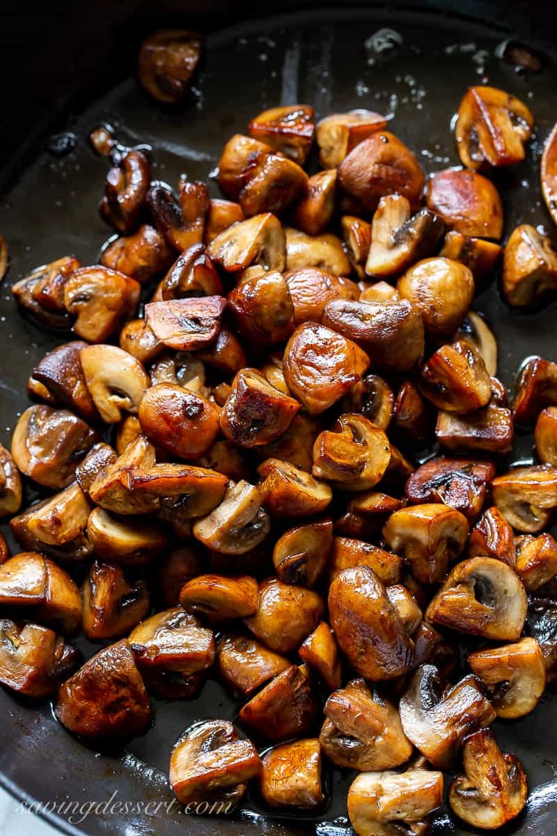 A cast iron skillet filled with cooked mushrooms