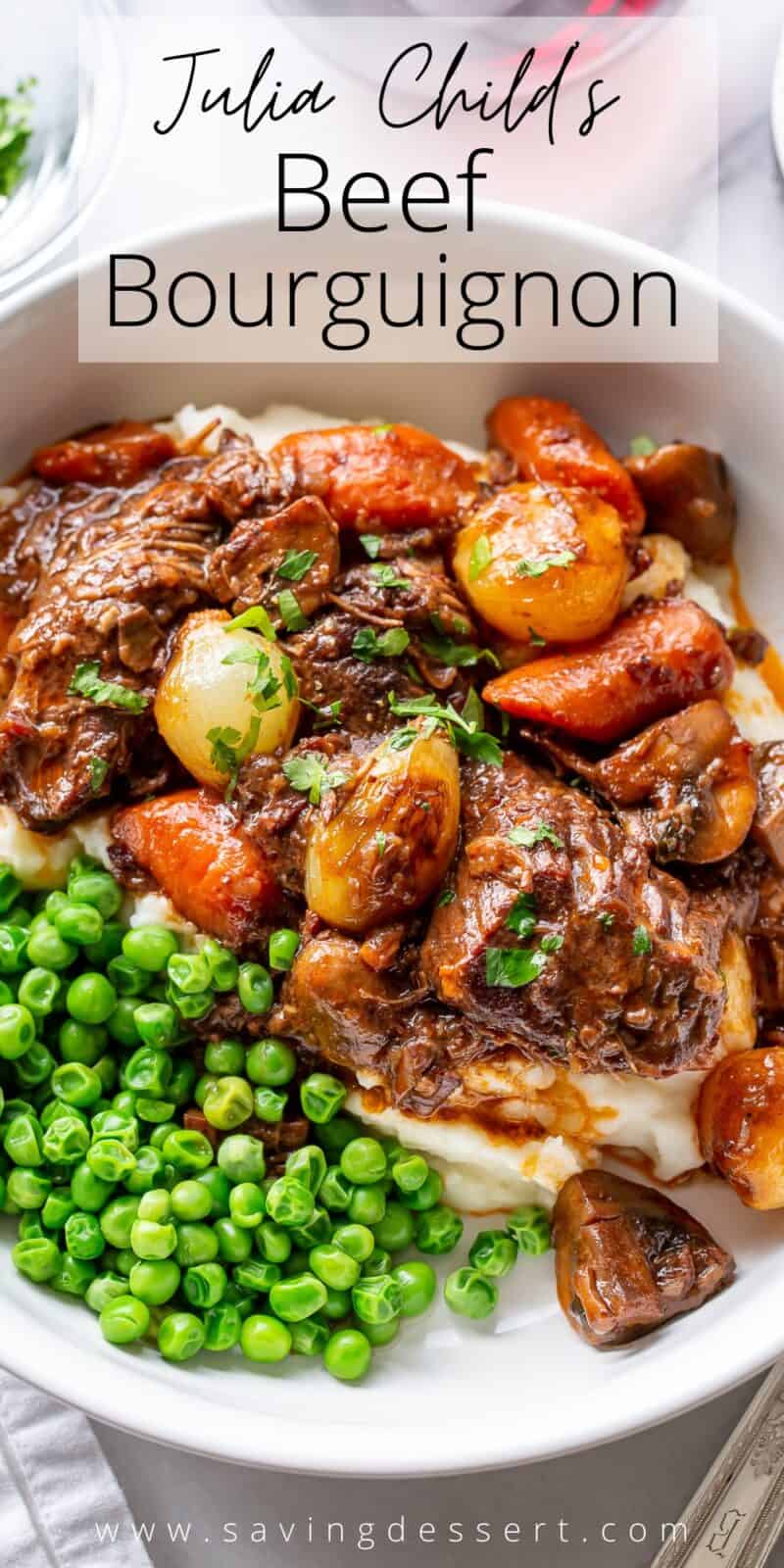 Julia Child's Beef Bourguignon served in a bowl over mashed potatoes and served with peas