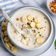 Overhead view of a bowl of creamy New England style Clam Chowder served with oyster crackers