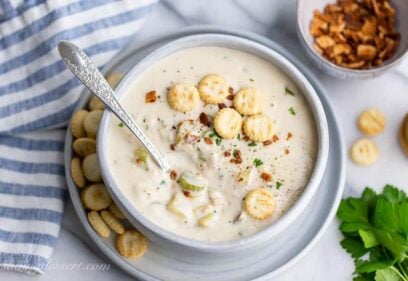 Overhead view of a bowl of creamy New England style Clam Chowder served with oyster crackers