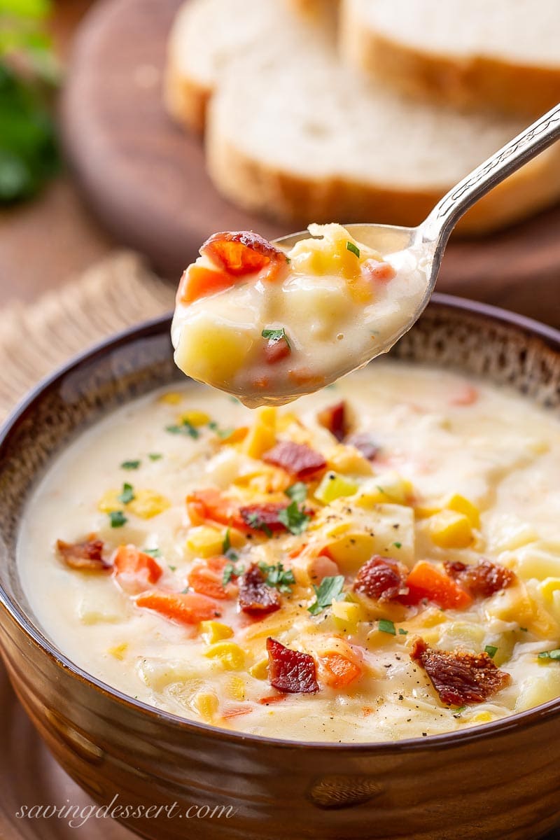 A spoonful of corn and potato chowder with bacon and parsley