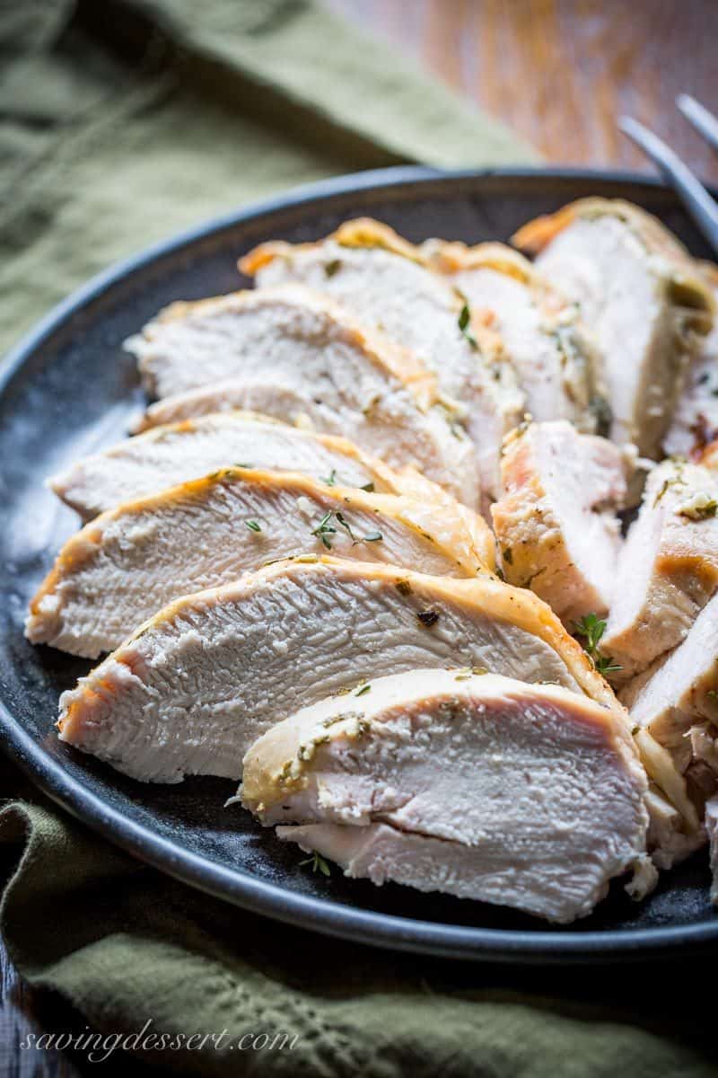 A black plate filled with sliced turkey breast