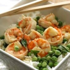 overhead shot of bowl with shrimp and peas over rice