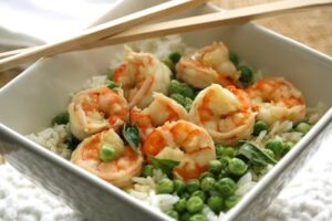 overhead shot of bowl with shrimp and peas over rice