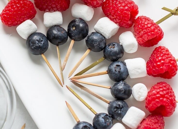 Red, white and blue fruit kabobs with marshmallows, blueberries and raspberries.